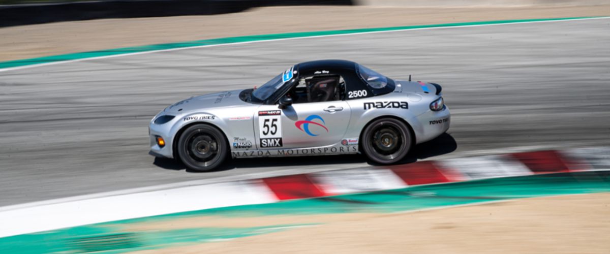 Alex Berg taking a corner in a Mazda sports car with Penn Elcom's logo on it