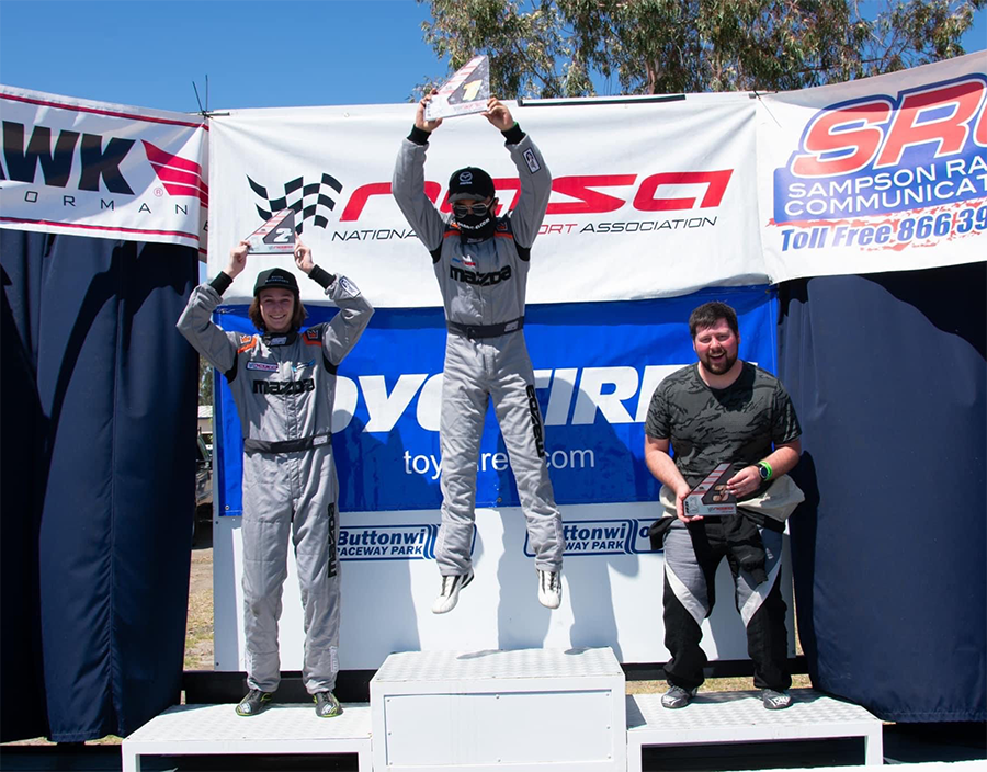Alex holding a trophy on winner's podium
