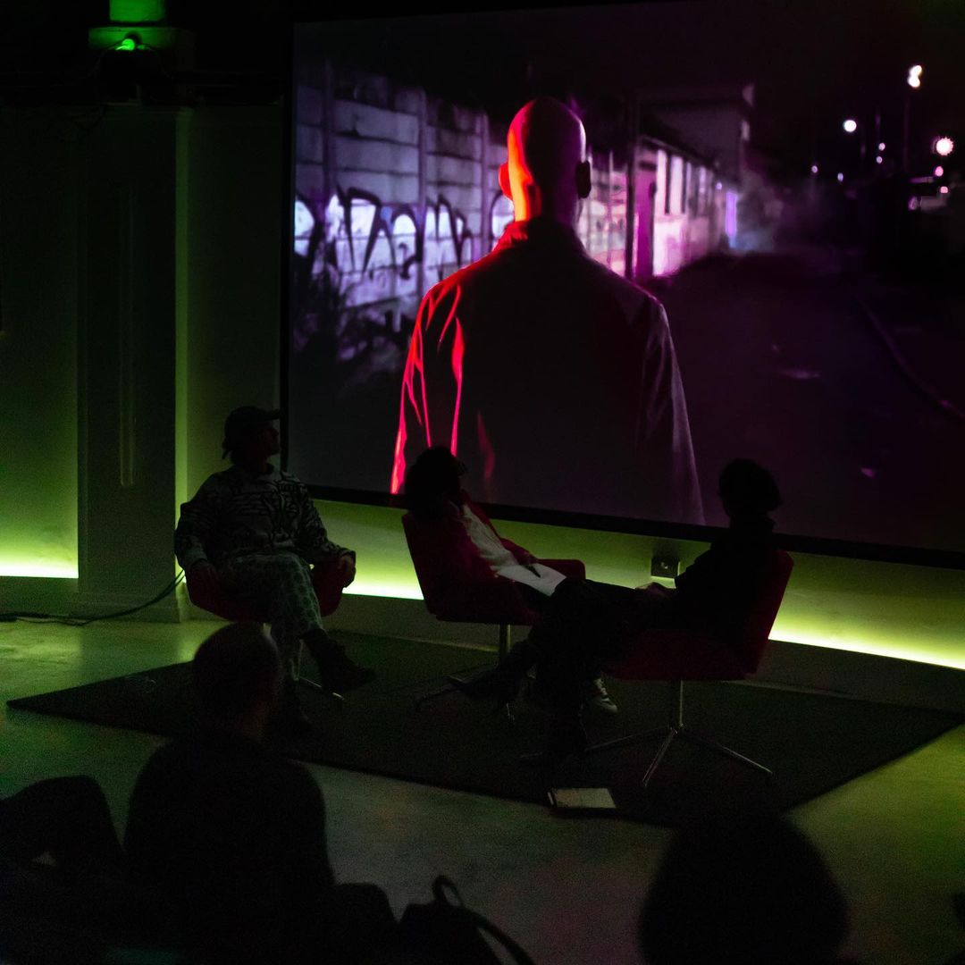 Audience watching a clip of footage playing onstage.