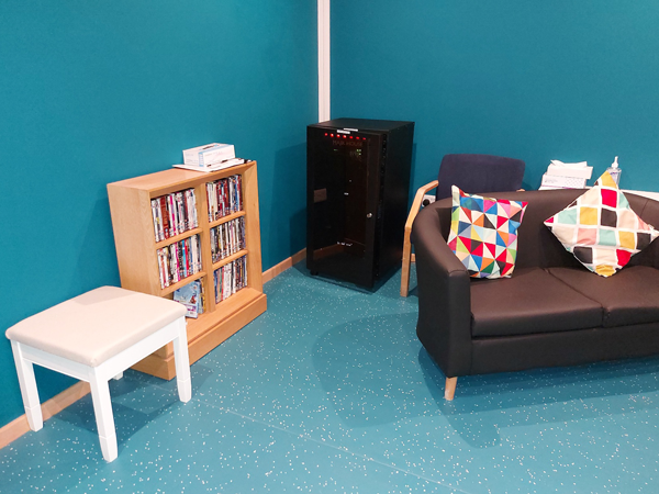 Film collection and colourful cushions on couch.