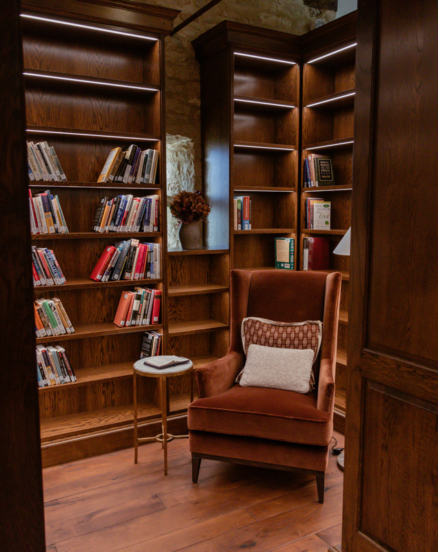 Brown shelves in Library with large brown arm chair and books
