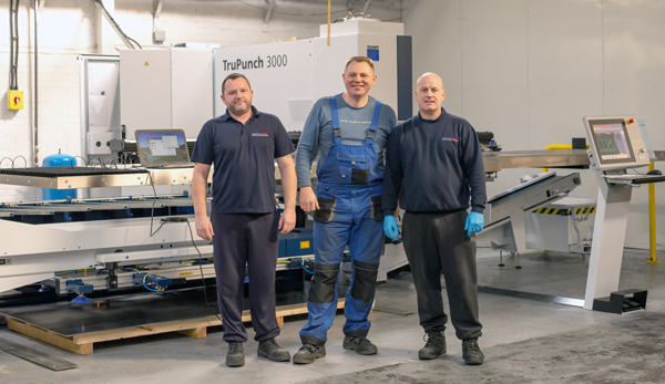 Penn Elcom staff in front of TruPunch Machine